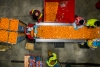 Overhead view of four Lineage employees sorting oranges in a cold storage food warehouse.