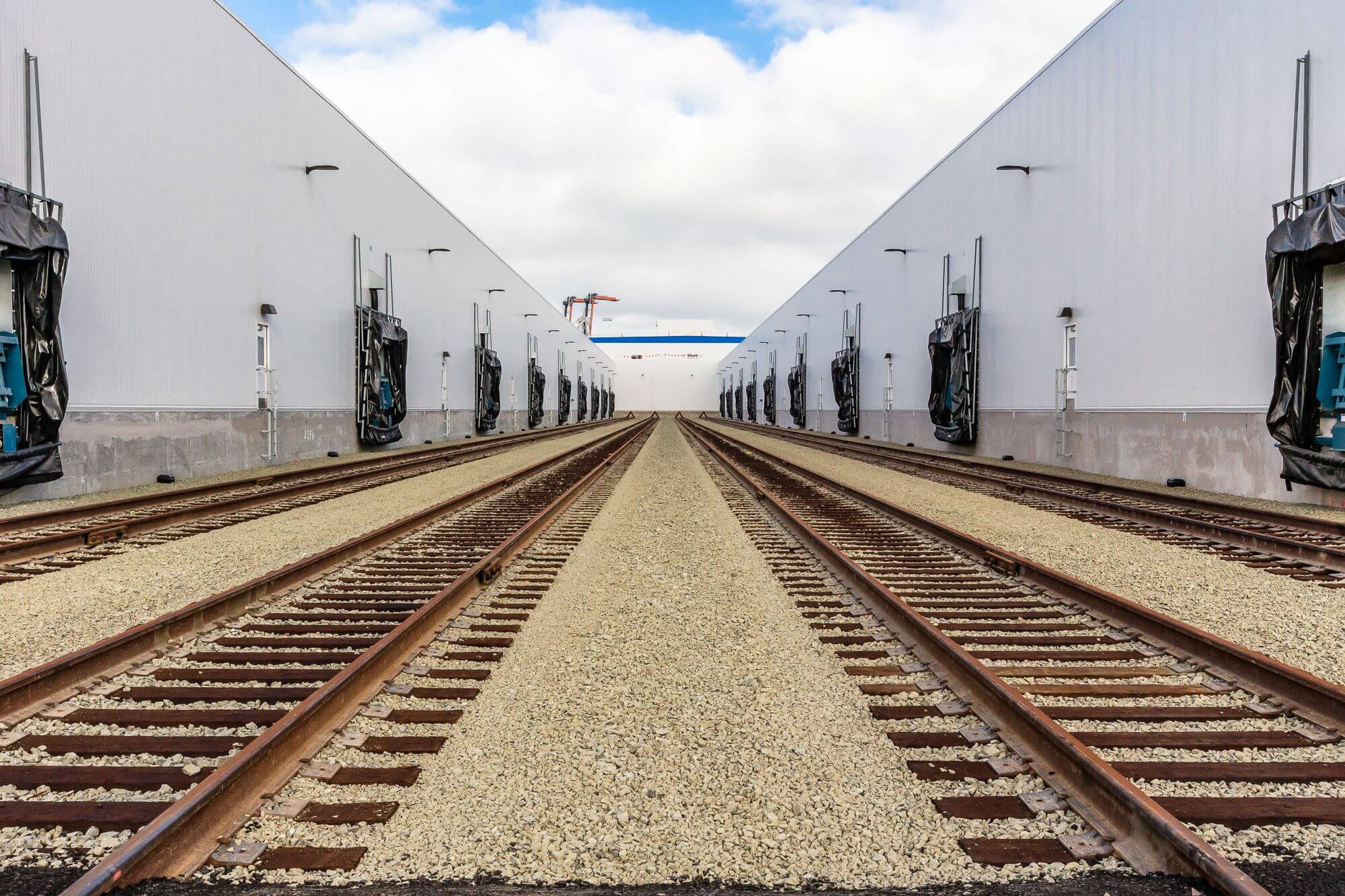 Train tracks leading to Lineage cold storage warehouse for moving and storing temperature-controlled food.