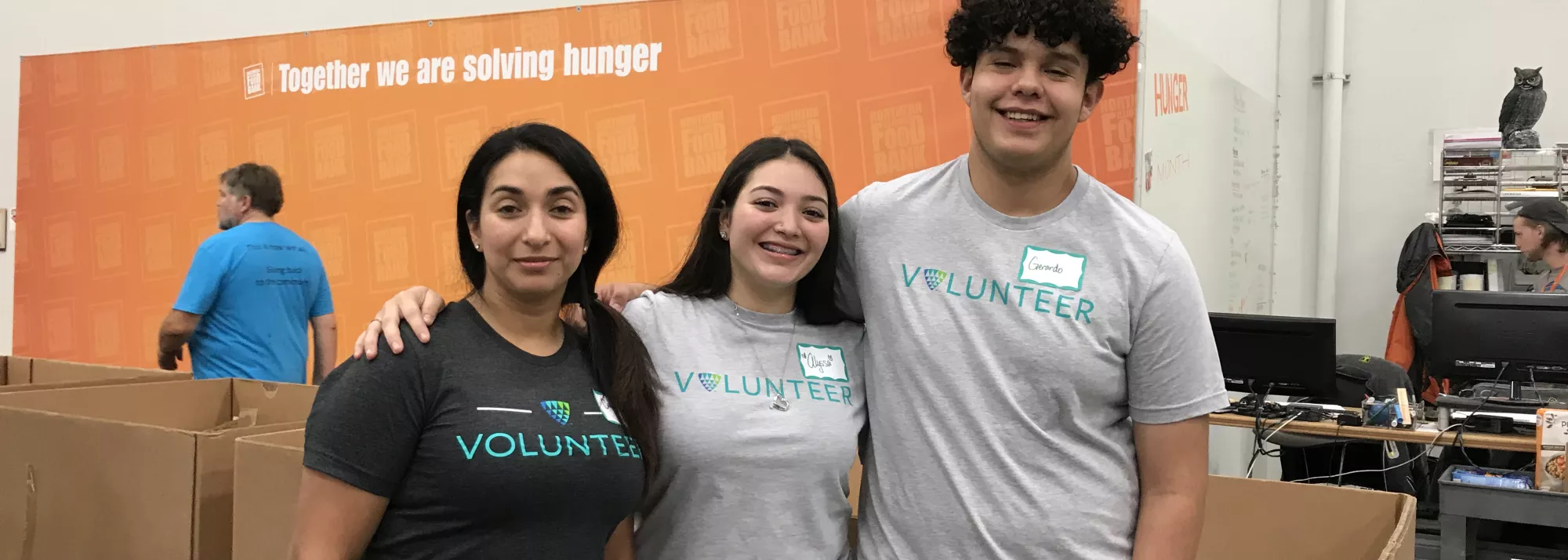 Three Lineage volunteers pose for a photo while working in a food bank