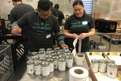 Team member volunteers repacking canned goods