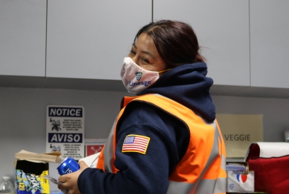 Female worker with mask in break room with pepsi